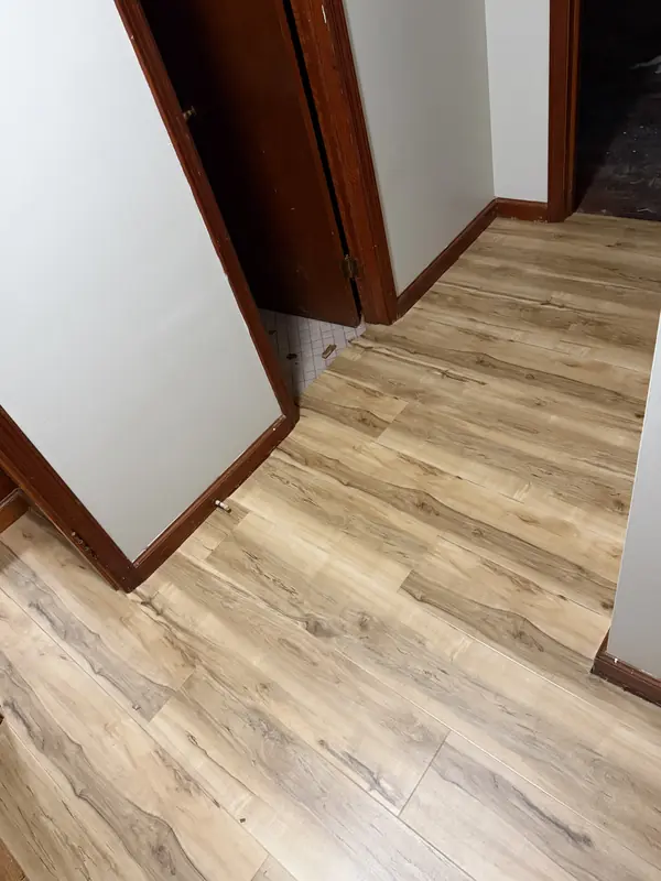 Wood-look LVP flooring running through a residential hallway and doorway