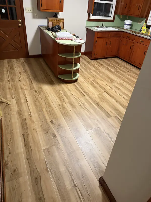 Wood-look luxury vinyl plank flooring installed throughout a kitchen with wood cabinets near Hickory NC